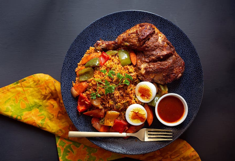 A serving of West African jollof rice with chicken and accompaniments