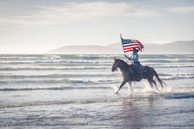 Someone on horse holding US flag