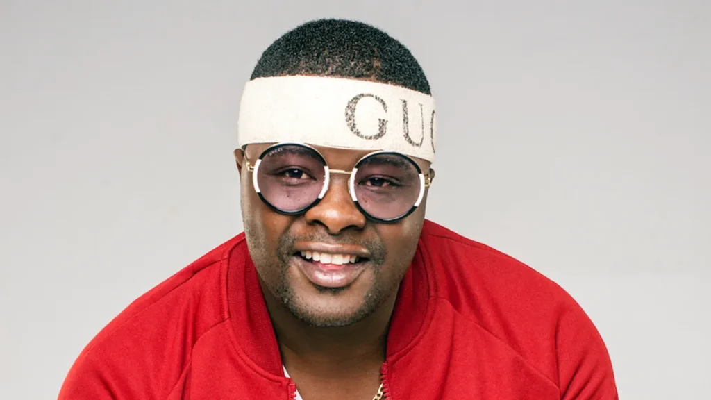 A portrait of DJ Sumbody rocking a Gucci bandana in front of a white backdrop