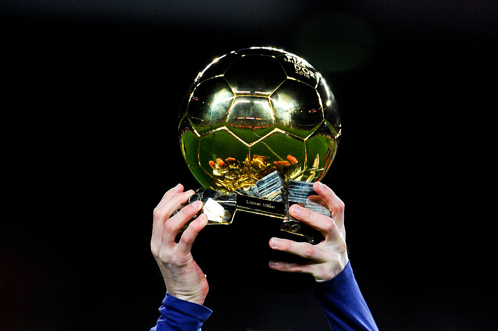 2012 Ballon d'Or winner, Lionel Messi, lifting up the award. Photo Credit- ESPN