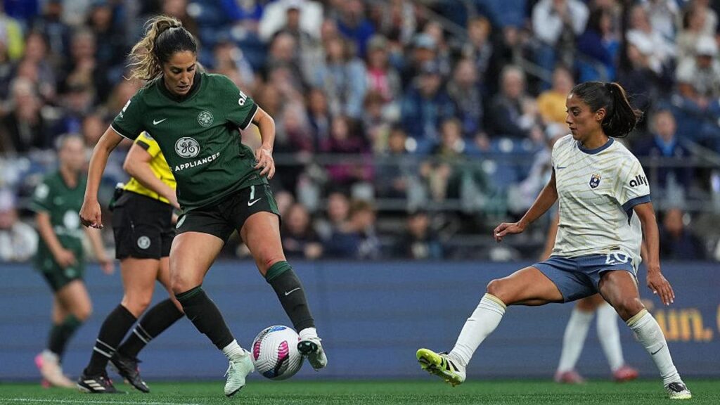 Savannah DeMelo of Racing Louisville FC is put under pressure by Sam Meza of Seattle Reign FC during the NWSL match between Seattle Reign and Racing Louisville at Lumen Field on September 14, 2025 in Seattle. Image Credit: Soobum Im/NWSL/Getty Images