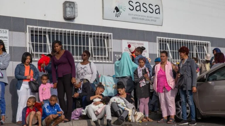 South Africans queue before a SASSA office to collect social grants. Photo Credit- Business Tech