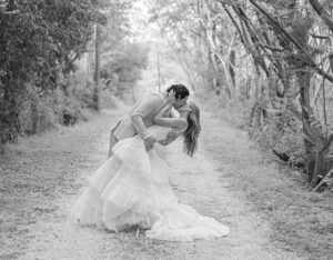 Perry Mattfield and Mark Sanchez share a kiss against a scenic backdrop. Image Credit: Diego Padilla Weddings