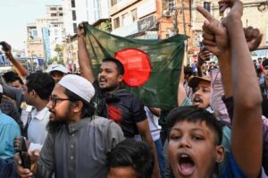 People wave Bangladesh’s national flag as they celebrate the court’s verdict in Dhaka. Photograph: Munir Uz Zaman/AFP/Getty Images