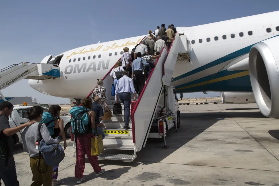 Passengers board a plane at Muscat International Airport. The Foreign Office said the flight will depart Oman's capital, Muscat, at 7pm on Wednesday | GETTY