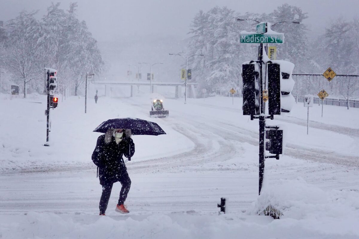 A pedestrian navigates a snow-covered sidewalk in Iowa City, Iowa. Scott Olson / Getty Images