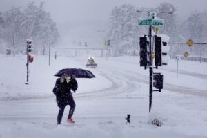 A pedestrian navigates a snow-covered sidewalk in Iowa City, Iowa. Scott Olson / Getty Images