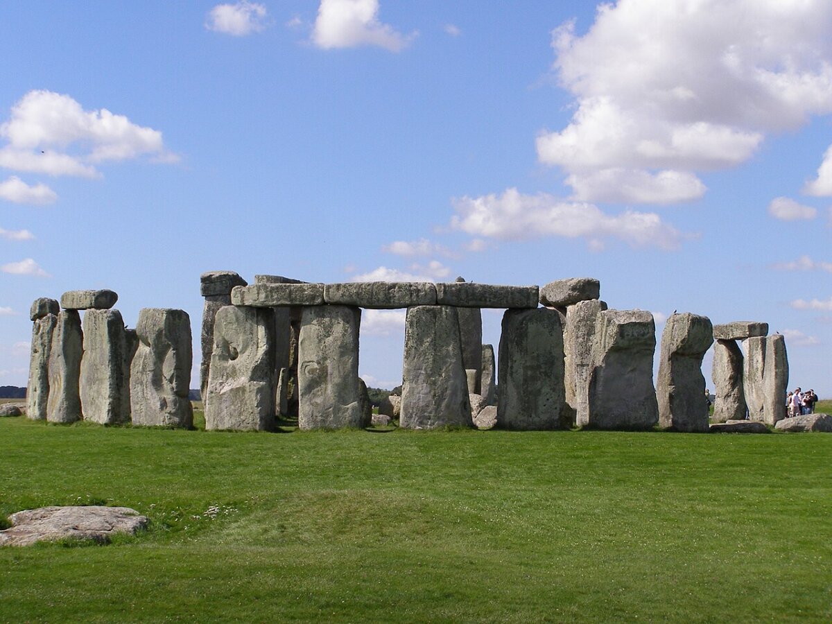 Stonehenge’s standing stones and lintels beneath a cloudy blue sky